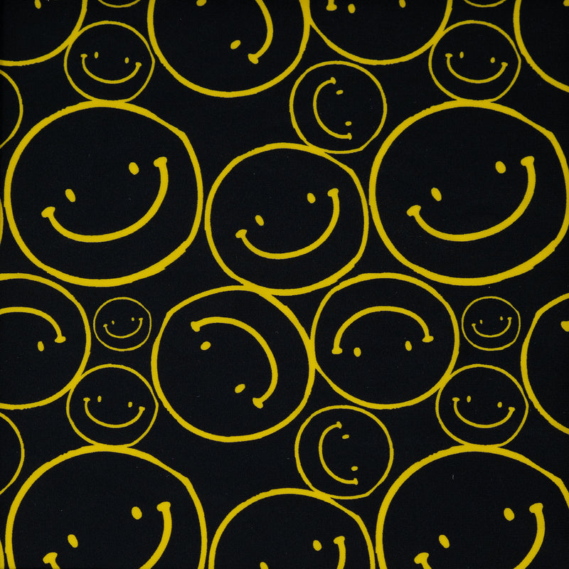 Flat sample shot of All Smiles Printed Spandex. The print is of vibrant yellow smiley faces of various sizes on a black background.