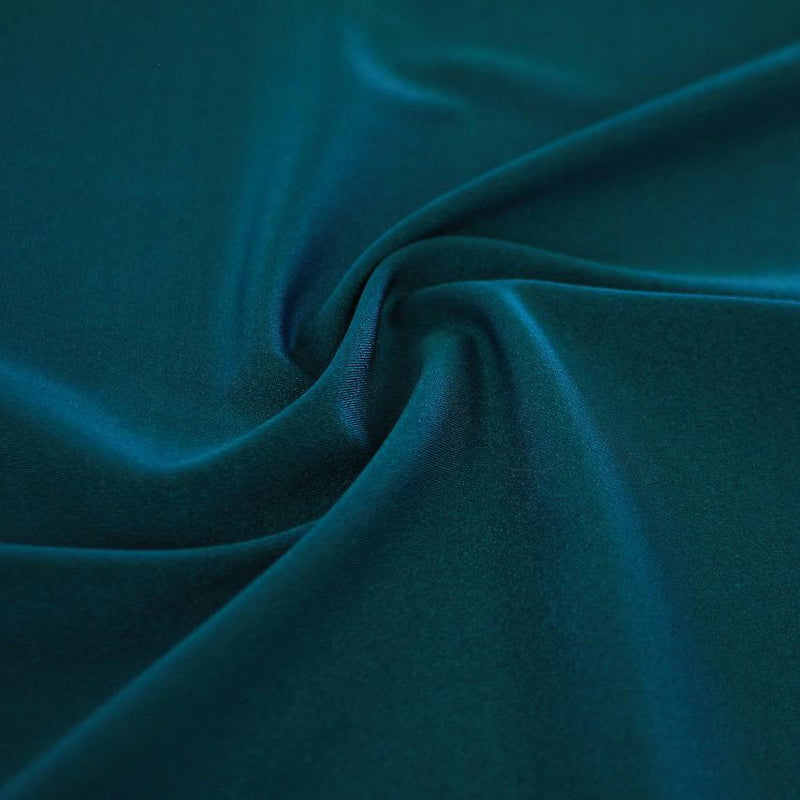 A swirled sample of Charisma shiny nylon spandex in the color aquamarine.
