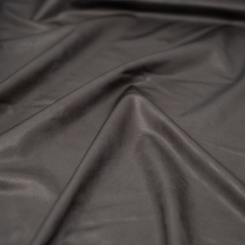 A crumpled piece of Cowboy Faux Leather Foil Printed Spandex in the color Grey