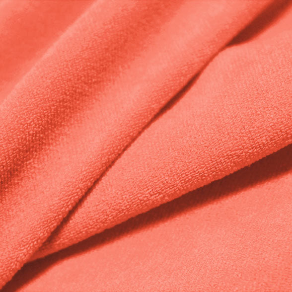A folded piece of Cozy Polyester Spandex Terry Cloth in the color peachberry.