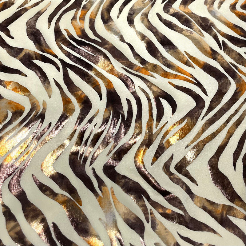 A flat sampele of desert zebra foil printed spandex in Ivory Shiny Foil.