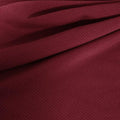 A draped sample of double ribbed spandex in the color burgundy.