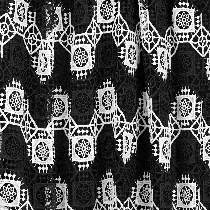 A draped sample of frequency mechanical lace in the color black and white.