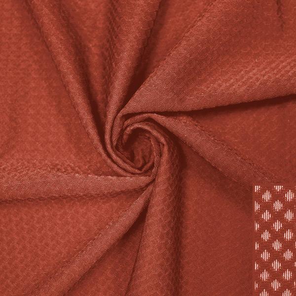 A swirled piece of Hive Textured Spandex in the color picante.