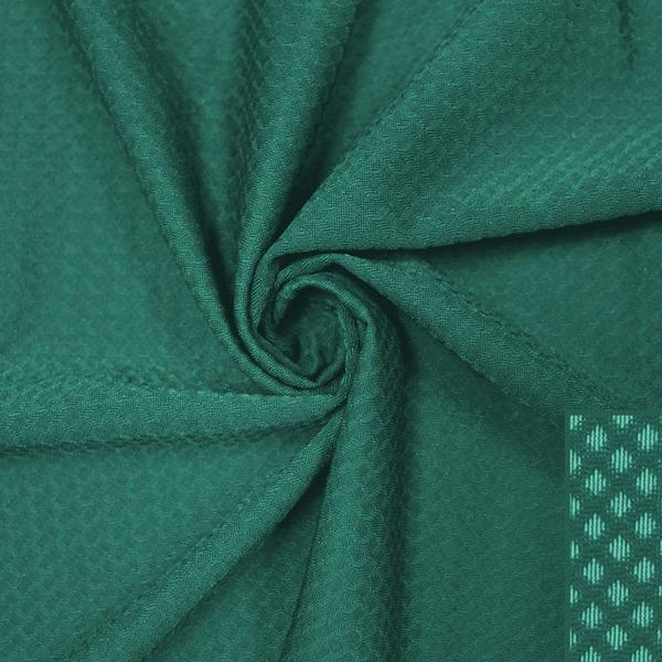 A swirled piece of Hive Textured Spandex in the color spruce.