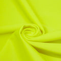 A swirled piece of matte nylon spandex fabric in the color chartreuse.