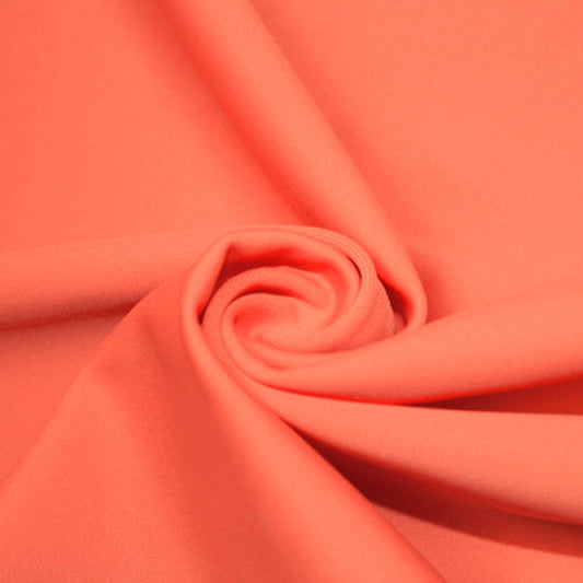 A swirled piece of matte nylon spandex fabric in the color coral.