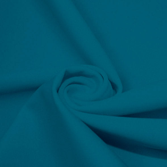 A swirled piece of matte nylon spandex fabric in the color new jade.