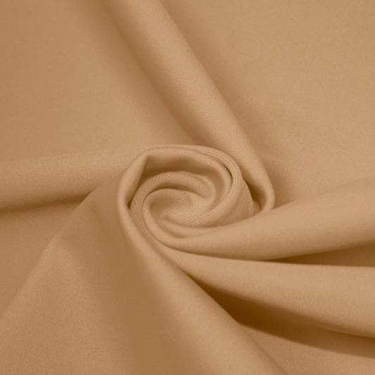 A swirled piece of matte nylon spandex fabric in the color nude.