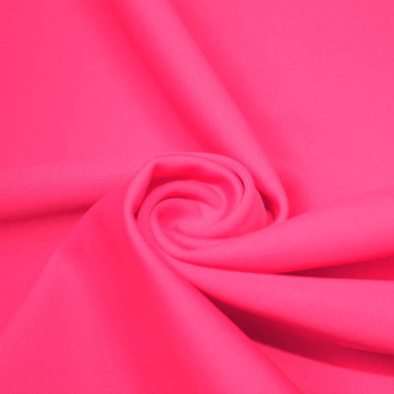 A swirled piece of microfiber nylon spandex in the color neon pink.