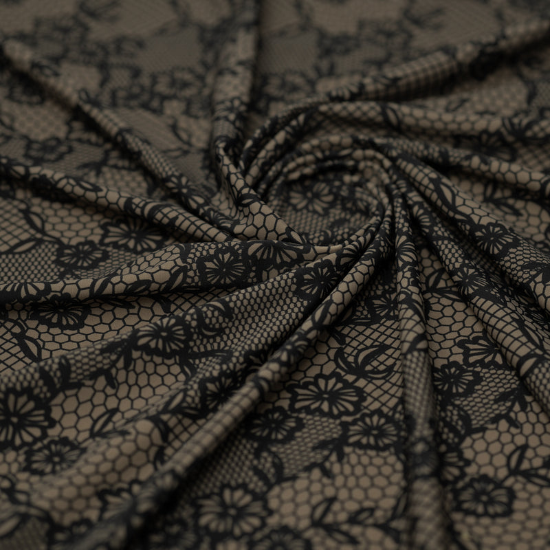 Swirled piece of Black Illusion Lace Pattern on Brown Printed Spandex