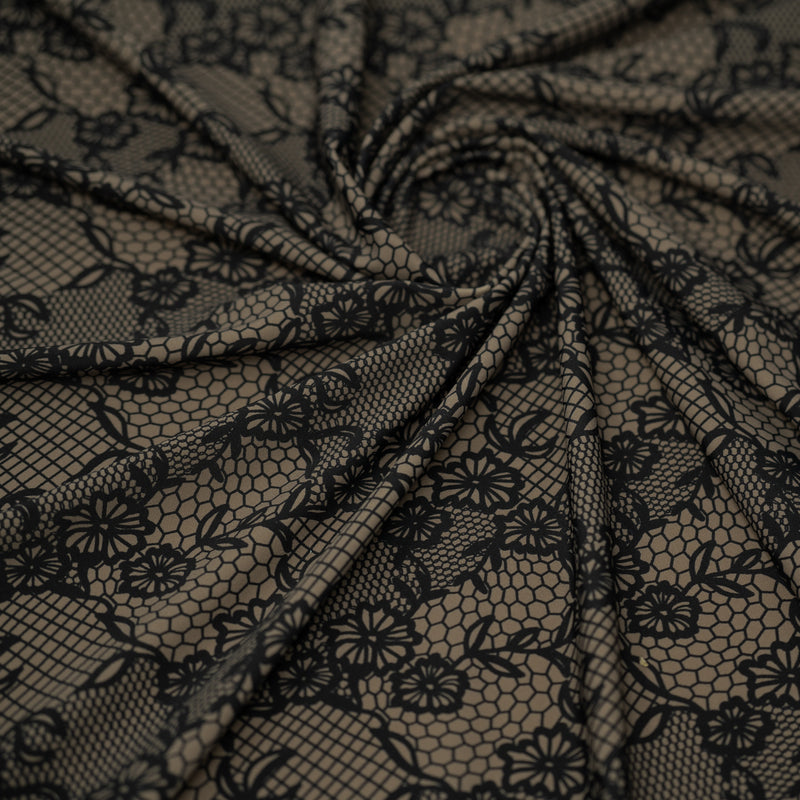 A swirled piece of Black Illusion Lace Pattern on Brown Printed Spandex