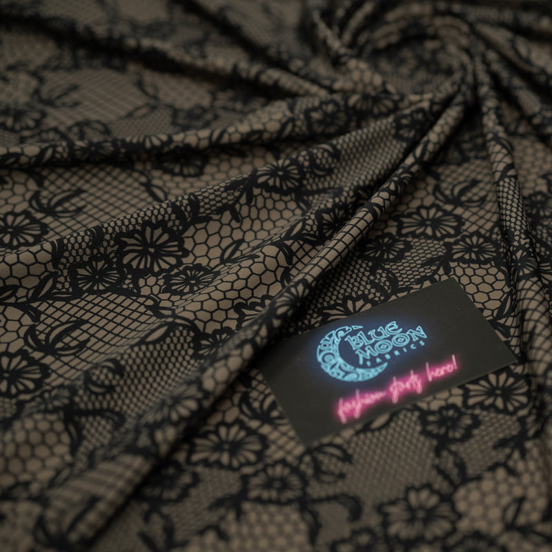 A swirled piece of Black Illusion Lace Pattern on Brown Printed Spandex