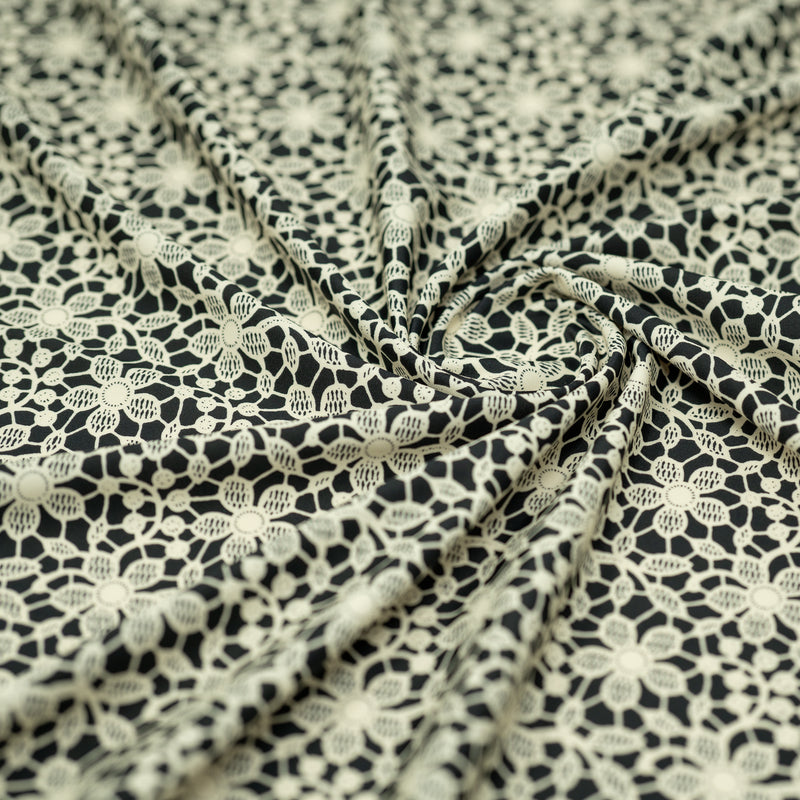 Swirled sample shot of vory Flower Lace Pattern on Black Printed Spandex
