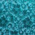 A flat sample of nadia scalloped stretch lace in the color peacock blue.