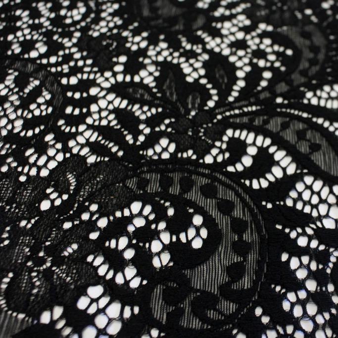 A flat sample of paige stretch lace in the color black.
