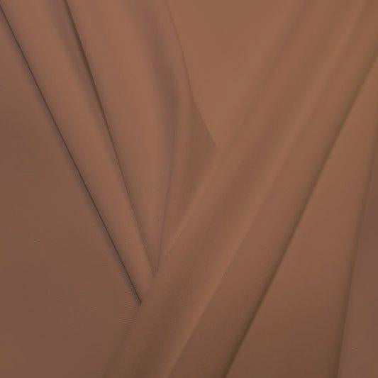 A pleated piece of performance nylon spandex fabric in the color fawn.