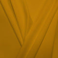 A pleated piece of performance nylon spandex fabric in the color medallion yellow.