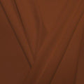 A pleated piece of performance nylon spandex fabric in the color sweet syrup.
