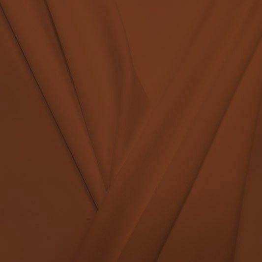 A pleated piece of performance nylon spandex fabric in the color sweet syrup.