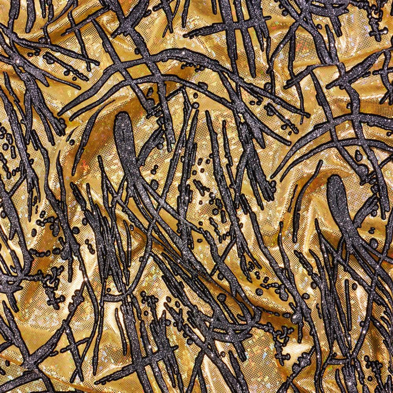 A flat sample of pollock shttered glass foiled spandex in the color gold.
