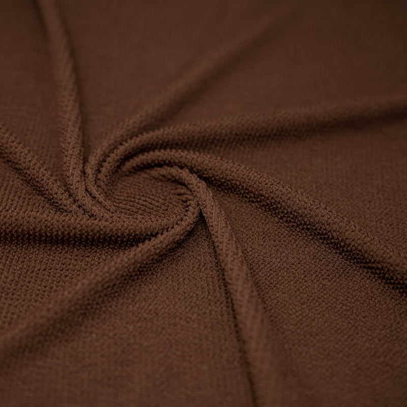 A swirled sample of popcorn polyester spandex jacquard in the color Bungalow.