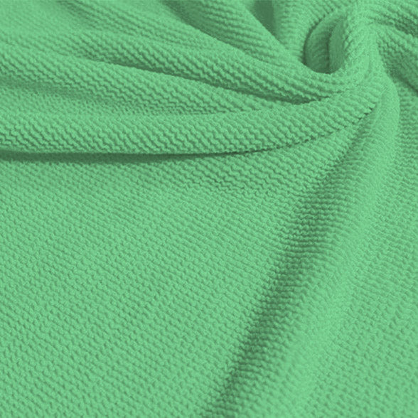 A swirled sample of popcorn polyester spandex jacquard in the color menthol.
