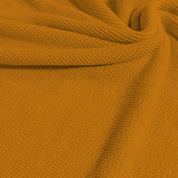 A swirled sample of popcorn polyester spandex jacquard in the color sunset blvd yellow.