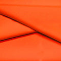 A folded piece of Ripple Recycled Polyester Spandex in the color orange.