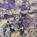 A folded sample of  squall foiled tie-dye spandex in the color Eggplant-Gold