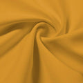 A swirled piece of Synergy Polyester Lycra in the color honey.
