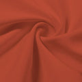 A swirled piece of Synergy Polyester Lycra in the color picante.