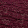 A flat sample of versailles burn out stretch velvet in the color burgundy.