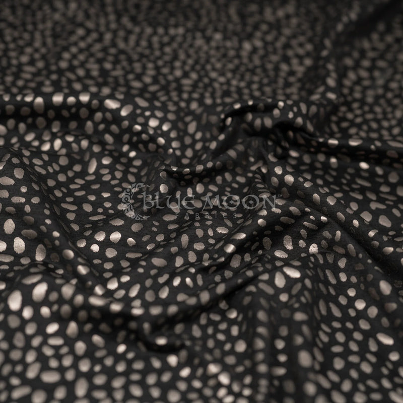 A crumpled piece of Abstract Animal Foil Printed Spandex in color Black/Matte Gunmetal.