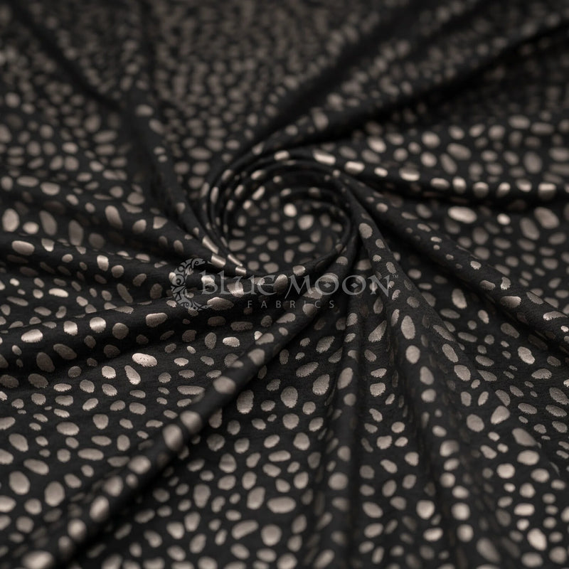 Swirled piece of Abstract Animal Foil Printed Spandex in color Black/Matte Gunmetal.