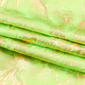 A folded sample of Thunder Hologram Spandex Fabric in the color Lime/Gold