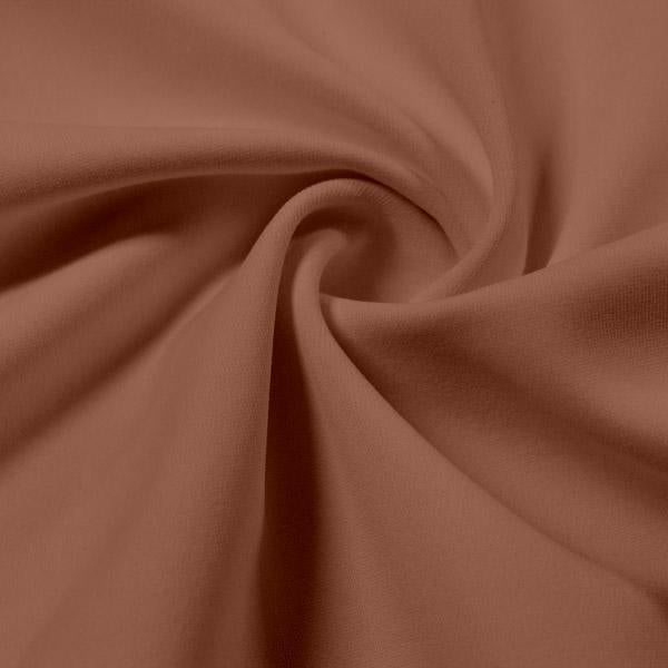 A swirled piece of Synergy Polyester Lycra in the color Fawn