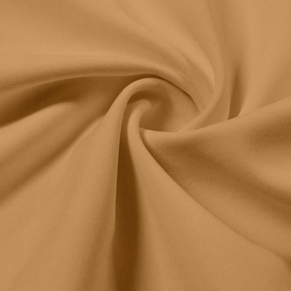 A swirled piece of Synergy Polyester Lycra in the color Soft Apricot