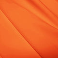 A flat sample of polyester lycra fabric in the color rust.