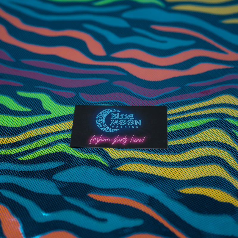 Detailed photograph of Fantastic Fever Foiled Spandex in the color Turquoise with a Blue Moon Fabrics standard size business card laid on top of the print for pattern sizing.