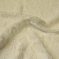 A swirled sample of Ada Stretch Lace in the color ivory.
