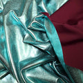 A crumpled piece of Alloy Foiled Spandex with teal foil on aubergine spandex.
