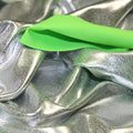 A crumpled piece of Alloy Foiled Spandex with silver foil on electric lime spandex.