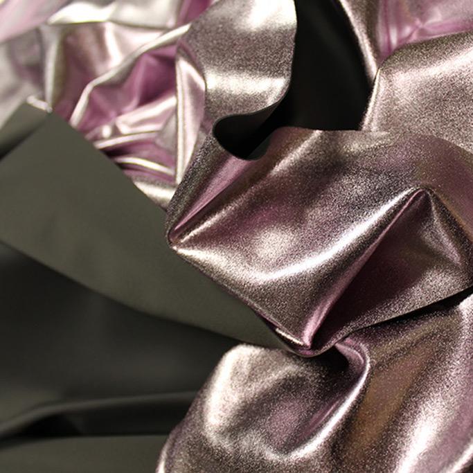 A crumpled piece of Alloy Foiled Spandex with light purple foil on graphite spandex.