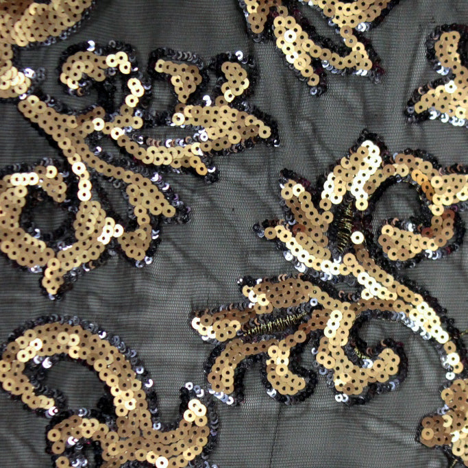 A flat sample of applique stretch mesh sequin with gold sequin on black mesh.