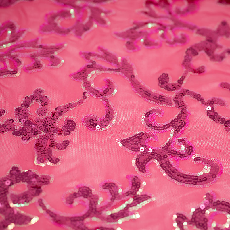 A flat sample of applique stretch mesh sequin with pink sequin on pink mesh.