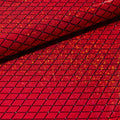 A folded sample of argyle shattered glass foiled spandex in the color red.