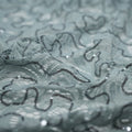 A crumpled piece of Ashley stretch lace sequin in the color grey.