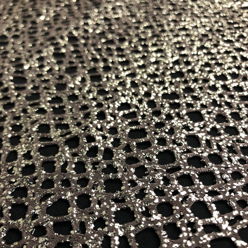 A flat sample of centerstage foiled stretch netting in the color gold.