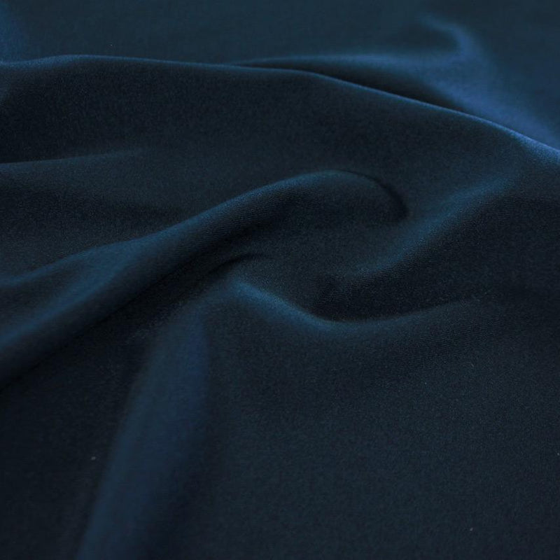 A swirled sample of Charisma shiny nylon spandex in the color deepsea.